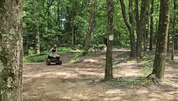 ATV riders on a tree-lined trail at NJ ATV Rentals