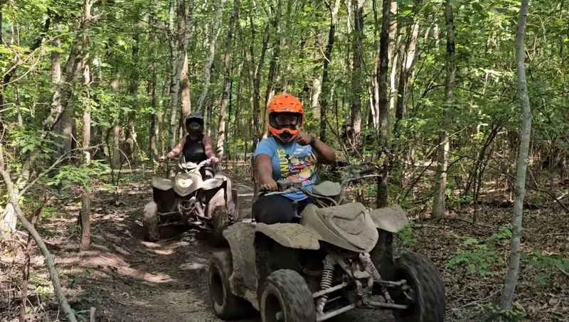 Rider in an orange helmet leading a tour through the woods